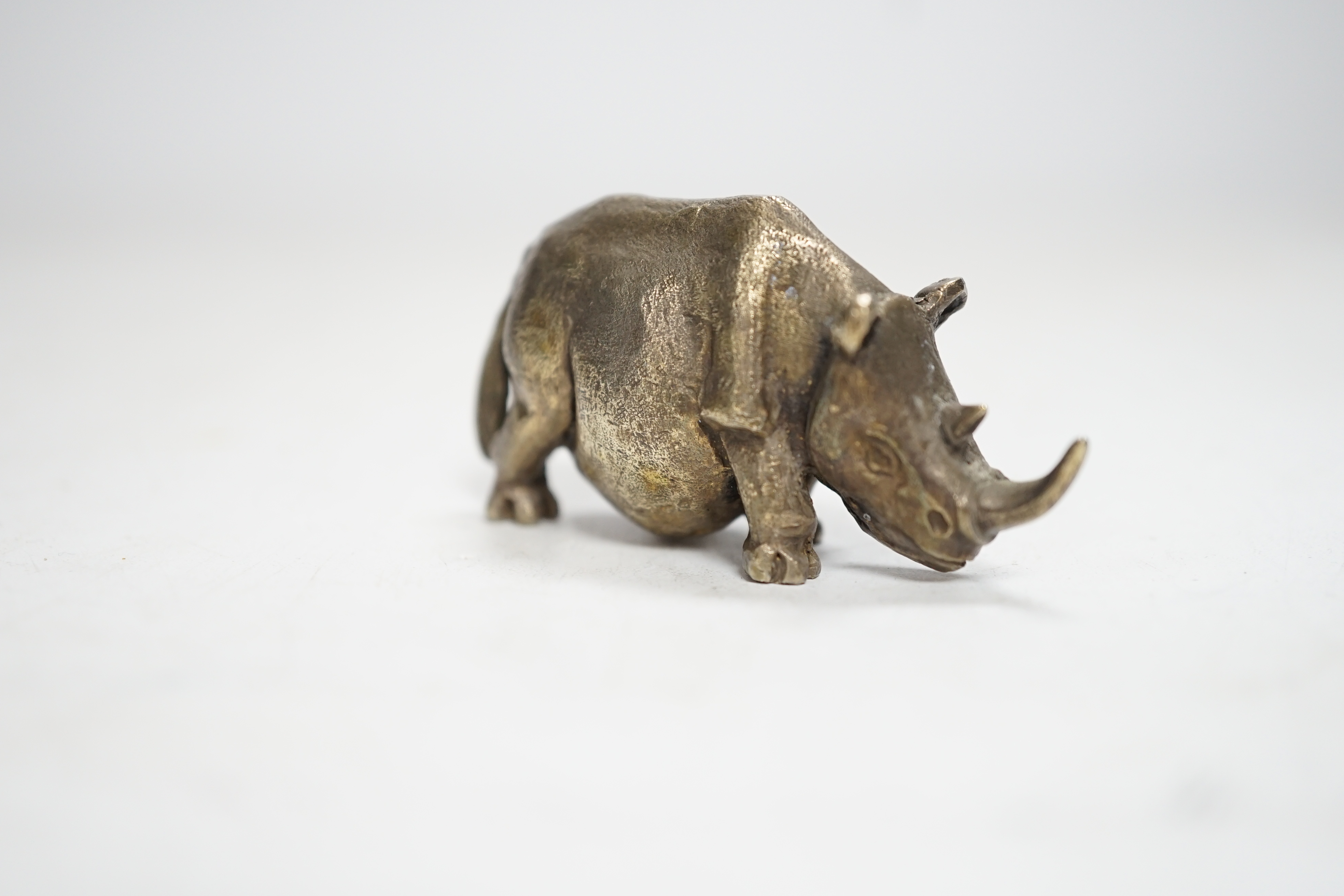 An Elizabeth II silver miniature model of a rhinoceros, by Stuart Devlin, London, 1985, length 55mm.